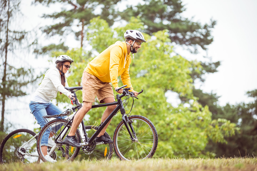 Couple heureux qui se promène à vélo